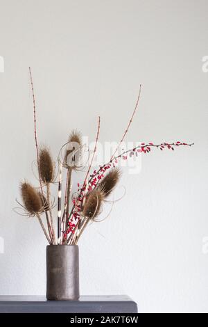 Eine ungewöhnliche Blumenschmuck der Karde, dappled Weidenzweige, Japanisch Berberitze, und Stachelschwein Stacheln. Stockfoto