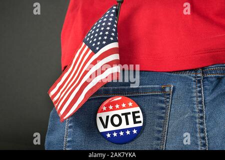 Wahl Abstimmung Pin auf Blue jean Pocket mit amerikanischer Flagge und rotes Hemd Stockfoto