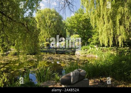 Teich und Brücke durch Äste im Frühling, Centre de la Nature, Saint-Vincent-de-Paul, Laval, Quebec, Kanada. Stockfoto