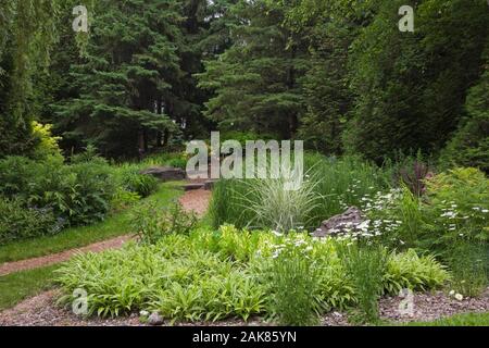 Zu Fuß weg und Blumen im Frühling in einem Garten in der Mitte de la Nature, Saint-Vincent-de-Paul, Laval, Quebec, Kanada. Stockfoto