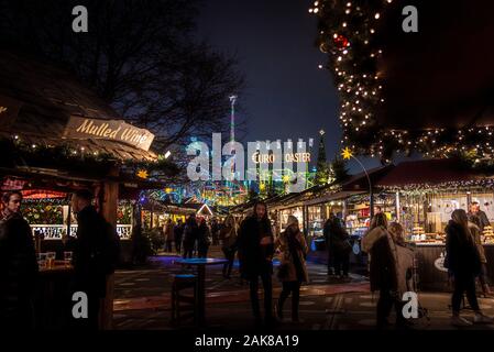 LONDON, ENGLAND, 28. Dezember 2018: Personen, die einen angenehmen Aufenthalt in einer Weihnachtsmarkt, umgeben von Essen und Trinken steht, mit Lichtern dekoriert Stockfoto