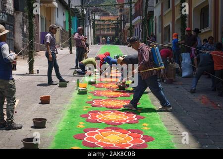 Santiago Atitlan, Guatemala - 30. März 2018: die Menschen vor Ort die Bewässerung der alfombra, bunten Sägespänen Teppiche für Semana Santa, Ostern auf der Straße Stockfoto