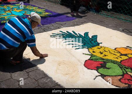 Santiago Atitlan, Guatemala - 30. März 2018: Lokaler Mann die alfombra, bunten Sägespänen Teppich für die Semana Santa, Ostern Finishing auf der Straße Stockfoto