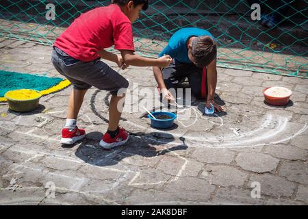 Santiago Atitlan, Guatemala - 30. März 2018: Die einheimischen Kinder, alfombra, bunten Sägespänen Teppiche für Semana Santa, Ostern auf der Straße Stockfoto