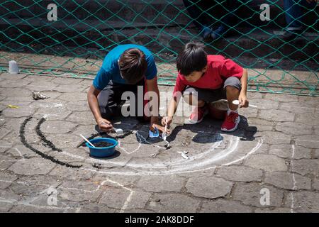 Santiago Atitlan, Guatemala - 30 März 2018: Lokale Kinder alfombra, bunten Sägespänen Teppiche für Semana Santa, Ostern auf der Straße Stockfoto