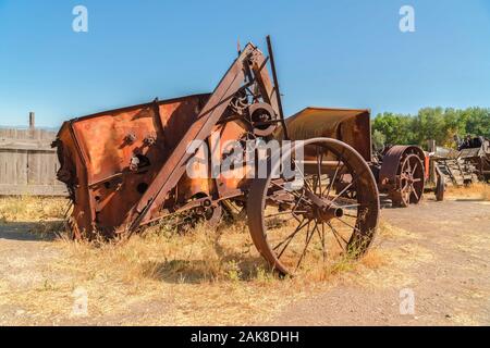 Nahaufnahme eines alten und vintage Traktor gegen Holzzaun und Licht blauer Himmel Stockfoto