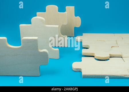 Stücke aus Holz puzzle Spiel aus Weiß unbemalt Sperrholz in enger gesehen - bis auf die blaue Fläche Hintergrund Stockfoto