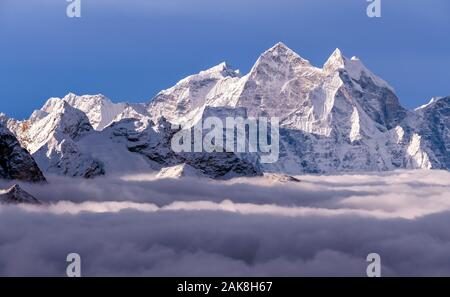 Majestätischen Himalaya Gipfel hoch über den Wolken bei Sonnenaufgang in Nepal, Himalaya Gebirge. Kangtega Peak (6782 m) auf der rechten Seite des Rahmens Stockfoto