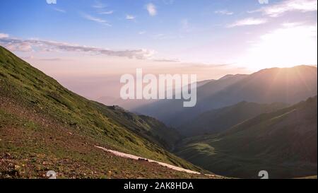 Aufgehenden Sonne mit ihren Strahlen leuchtet auf einem Berg Schlucht; Feder Wärme, ein Gefühl von Harmonie und Ruhe Stockfoto