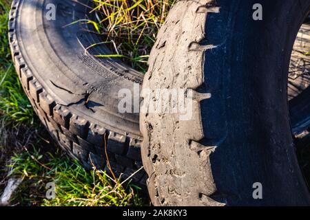 Alte Räder von unrecycled Autos in einer natürlichen Feld geworfen, die Erde zu verunreinigen. Stockfoto