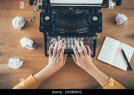 Writer, der auf Vintage-Schreibmaschine tippt, mit zerknautschtem Papier. Ideenkonzept Stockfoto