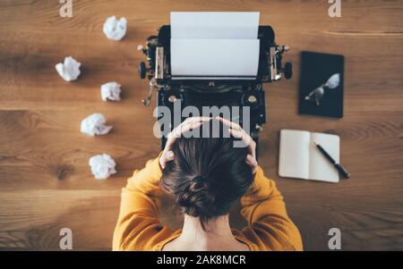 Draufsicht des Schreibers über Schreibmaschine und zerknautschtes Papier herum. Ideenkonzept Stockfoto