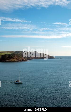 Ein Segelboot vergeht St Anthony Head und den Leuchtturm von St. Mawes, Cornwall, UK gesehen Stockfoto