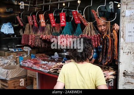 HongKong, China - November, 2019: Frau kaufen Fleisch auf traditionelle Metzger auf der Straße Markt Store in Hongkong Stockfoto