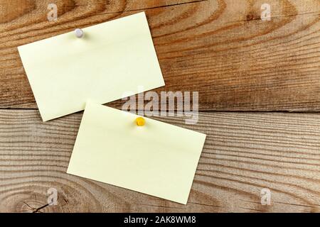 Eine verstiftete Stück Papier hängt an einer Holzwand. Stockfoto