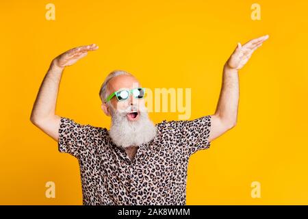 Foto von Tanzen fröhlicher Jubel coole alte Mann sich jung fühlen, tanzen vor gelb leuchtenden Hintergrund er ist über isoliert Stockfoto