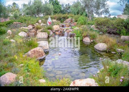 Kleiner Wasserfall oder Cascade in einem angelegten Garten Stockfoto