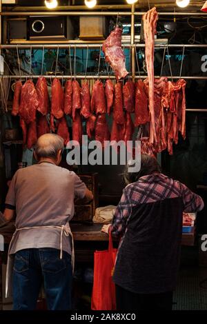 HongKong, China - November, 2019: Metzger Fleisch verkaufenden zu älteren Frau auf der Straße Markt Store in Hongkong Stockfoto