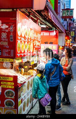 Chinatown Nankin-Machi in Motomachi, Kobe, Japan. Familie kaufen chinesische Street Food von kleinen Stall Verkauf von Nudeln, Klöße und Gyoza bei 300 Yen. Stockfoto