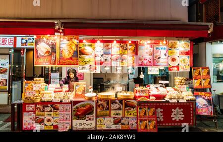 Chinatown Nankin-Machi in Motomachi, Kobe, Japan. Große Straße stall verkaufen verschiedene Gekochte chinesische Straße Nahrungsmittel einschließlich gedämpfte Teigtaschen. Abend Stockfoto
