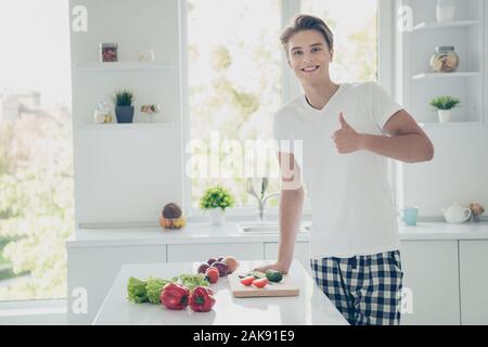 Porträt Seiner er schöne attraktive Heiter froh gelaunt zuversichtlich sportlicher Kerl, Vitamin veganen leckeren Salat mit thumbup auf der light White Stockfoto
