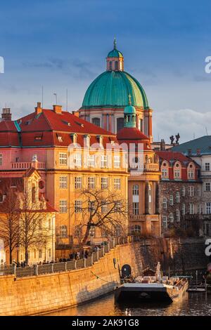 Prag, Tschechische Republik - Die weltberühmten St. Franziskus von Assisi Kirche Dome und traditionellen roten Dächer mit schönen goldenen Sonnenuntergang leuchten und klare Stockfoto