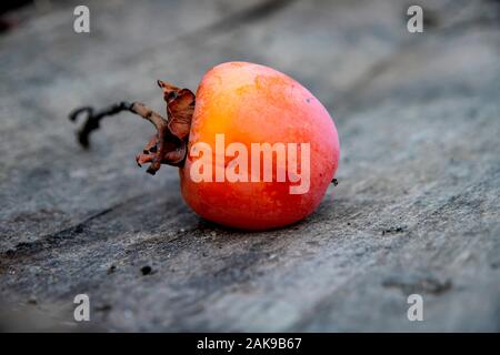 Reife Kaki Frucht close-up auf einer hölzernen Oberfläche. Georgien Stockfoto