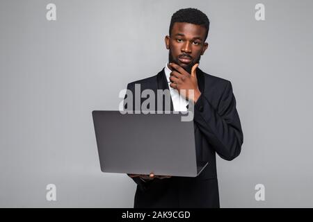 Fröhlich afrikanische amerikanische Mann mit Laptop mit leerer Bildschirm isoliert auf Grau Stockfoto