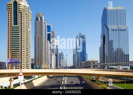 DUBAI, VEREINIGTE ARABISCHE EMIRATE - 22. NOVEMBER 2019: Sheikh Zayed Road mit Überführung und modernen Wolkenkratzern an einem sonnigen Tag, blauer Himmel Stockfoto