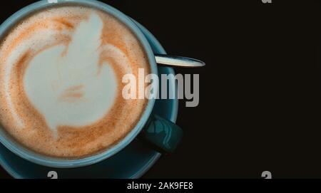 Latte schöne Künste Kaffee. Blaue Tasse heißen Kaffee auf der schwarzen Oberfläche. Stockfoto