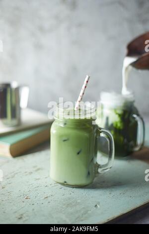Hausgemachte Eistee Matcha Latte Tee mit Milch. Stockfoto