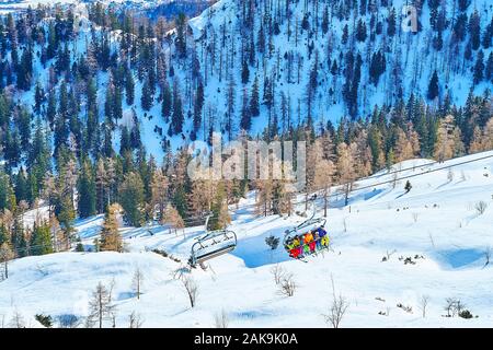 Der Skilift Kabinen, die Menschen entlang der weißen verschneiten Hang des Mount, Feuerkogel Ebensee, Salzkammergut, Österreich Stockfoto