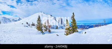 Feuerkogel Mountain Plateau mit Blick auf Alberfeldkogel mit Europakreuz auf der Oberseite, beeindruckenden schneebedeckten Dachstein Alpen mit Skiliften, Pisten und ein paar Stockfoto