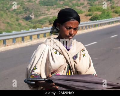 Äthiopischen Frauen in traditioneller Kleidung falten Sonnenschirm, Gondar, Äthiopien. Stockfoto