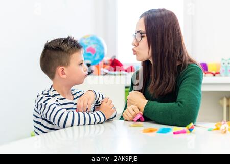 Kinder logopädische Therapie Konzept. Vorschulkind üben die richtige Aussprache mit einem weiblichen Logopädin. Stockfoto