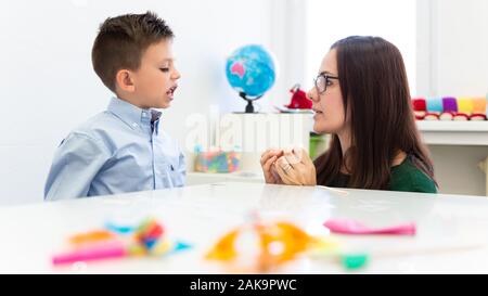 Kinder logopädische Therapie Konzept. Vorschulkind üben die richtige Aussprache mit einem weiblichen Logopädin. Stockfoto