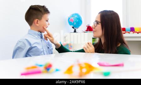 Kinder logopädische Therapie Konzept. Vorschulkind üben die richtige Aussprache mit einem weiblichen Logopädin. Stockfoto