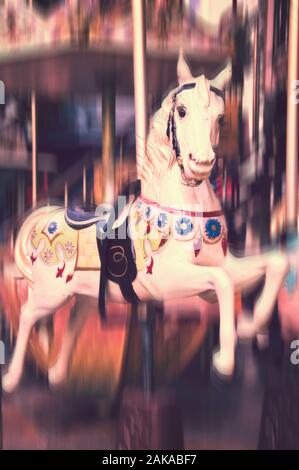 Vintage Karussell Pferd. Im antiken Stil geschnitzte Holz auf einem alten Amusement Merry go round, Bewegungsunschärfe. Stockfoto