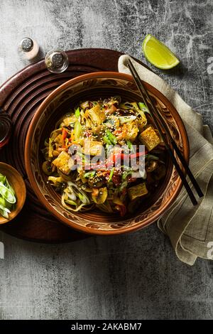 Asiatische vegan Pfannengerichte mit Tofu, Reis, Nudeln und Gemüse, Ansicht von oben. Stockfoto