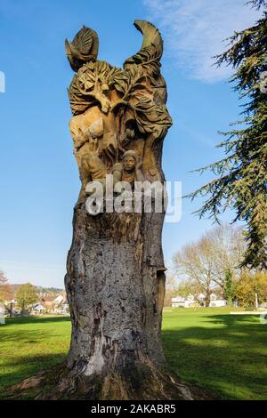 "Beim Blättern durch die Geschichte "holz skulptur in einen Baumstamm von Tom Harvey in Geisa Abbey Park, Rastenberg, Worcestershire, England, Großbritannien, Großbritannien geschnitzt Stockfoto