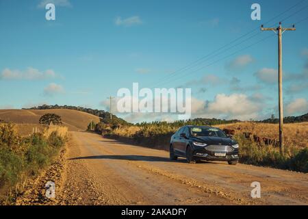 Auto auf unbefestigte Straße durch ländliche Tiefland namens Pampa in der Nähe von Cambara do Sul. Eine Stadt mit natürlichen Sehenswürdigkeiten im Süden Brasiliens. Stockfoto