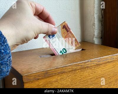 Man Geld spenden nach dem Gottesdienst Stockfoto