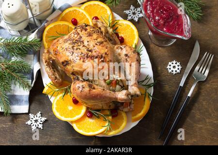 Konzept der Weihnachten oder Neujahr Abendessen gebratener Truthahn, gefüllt mit Reis und Cranberry Sauce auf Holztisch. Stockfoto