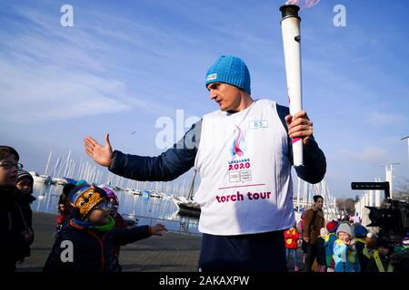 (200108) -- LAUSANNE, Januar 8, 2020 (Xinhua) - der Fackelträger Adam Scholefield läuft während des Fackellaufs für die 3 Jugend Olympischen Winterspiele in Lausanne, Schweiz, Jan. 8, 2020. (Xinhua / Wang Jianwei) Stockfoto