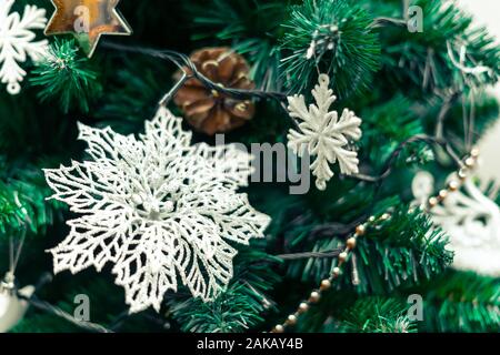 Weihnachtsschmuck, weiße Blume mit Garn, Christmas Ornament und weißen Stern. Schöne Aussicht auf den Weihnachtsbaum mit verschwommenen Hintergrund. Stockfoto