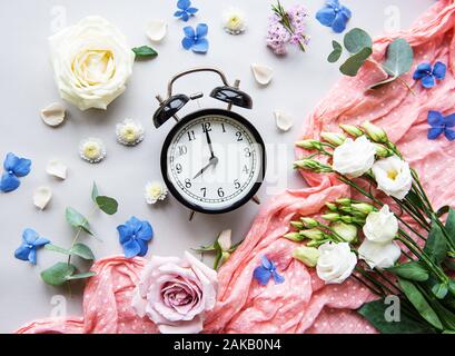 Blumen Komposition. Rahmen aus verschiedenen Blumen und Eukalyptus, Zweige und Wecker auf weißem Hintergrund. Flach, Ansicht von oben, kopieren Raum Stockfoto