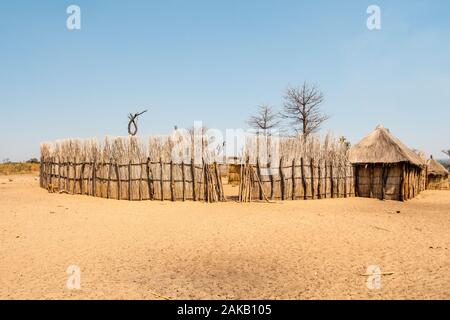 Mafwe Kral, einem traditionellen Homestead von Eingeborenen in Namibia mit hölzernen Zaun und Hütten Stockfoto