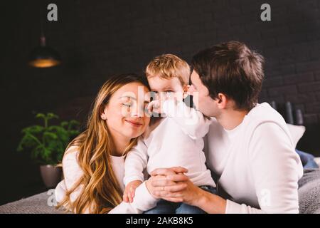 Glückliche Familie Spaß auf Bett zu Hause liegen. Happy Family im Bett. Mama, Papa und Sohn liegen auf Schlafzimmer in Türen. Vater, Mutter und Kind Stockfoto