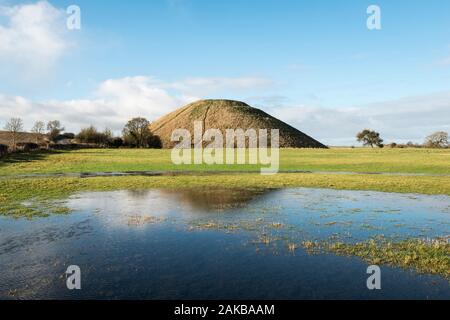 Der riesige neolithische Kreidehügel von Silbury Hill, Avebury, Wiltshire, Großbritannien, spiegelte sich in einer überfluteten Wiese wider. Er ist 40 m hoch und wurde um 2300 v. Chr. erbaut Stockfoto