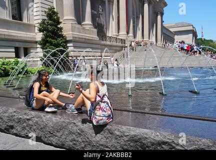 New York City, NY, USA. Apr 2017. Junge Frauen verschiedener Ethnien Spaß Spritzwasser außerhalb der Met in New York City. Stockfoto